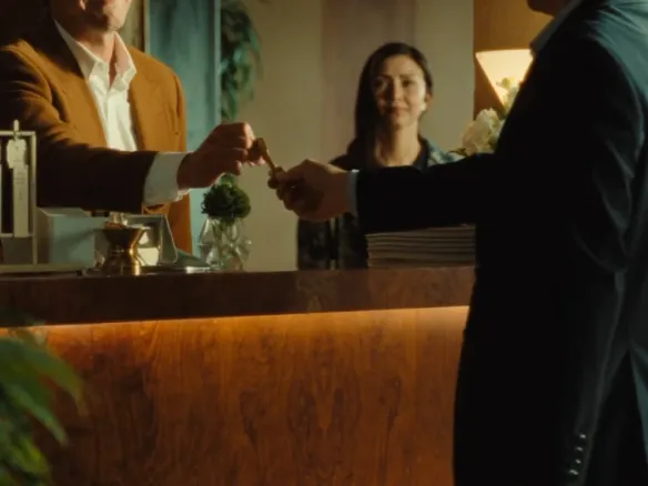 A hotel concierge handing a room key to a guest at reception